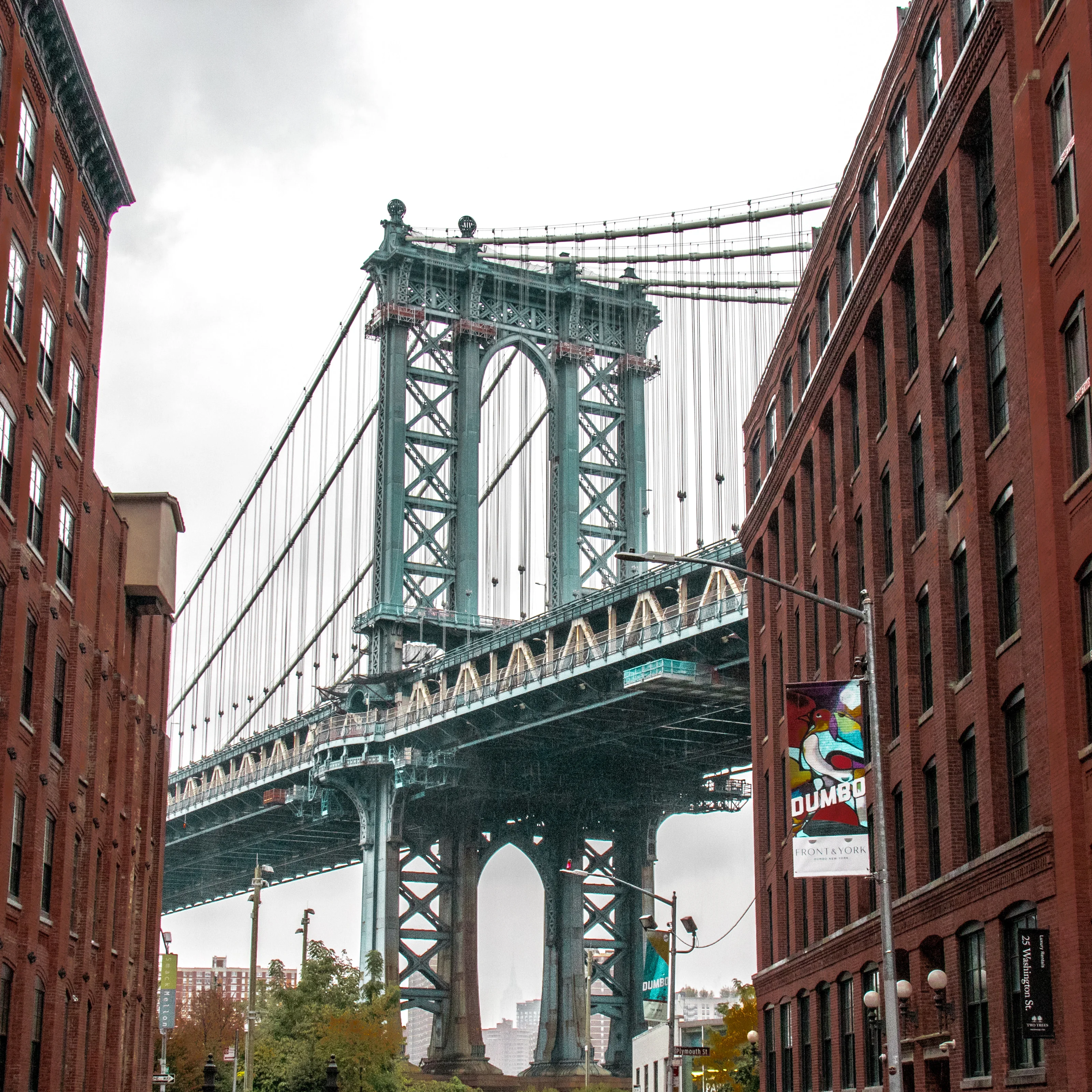 The Manhattan Bridge framed between red-brick buildings on Washington Street, DUMBO